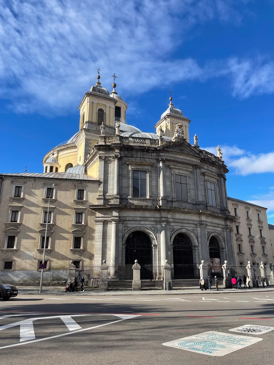 front of a historical building in madrid spain with an empty road in front of it.